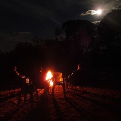 Enjoying an evening under a full moon around a raging campfire